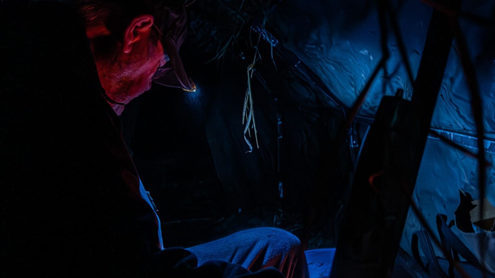 Hunter in the blind, red headlamp glow before legal light