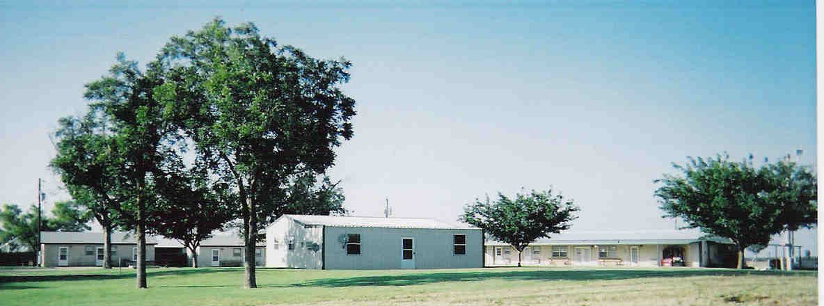 Wide view of the Big Honker Lodge property — main buildings, trees, and open Texas sky