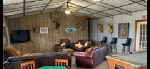 The social room — couches, pool table, big-screen TV